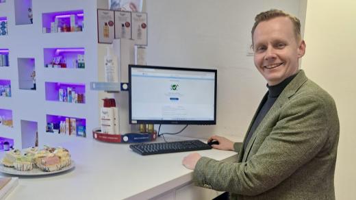 Apotheker Arjan Roelofs in Apotheek Pijnacker Centrum achter computer met Mitz