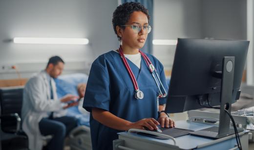 Verpleegkundige checkt gegevens patiënt op computer